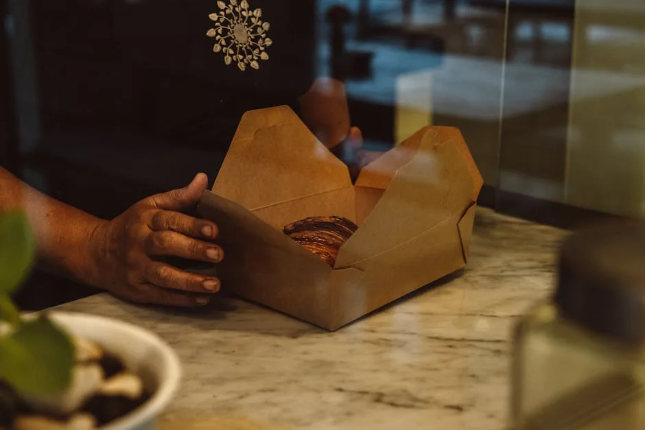 Mains emballant un pastel à Lisbonne dans une boîte en carton
