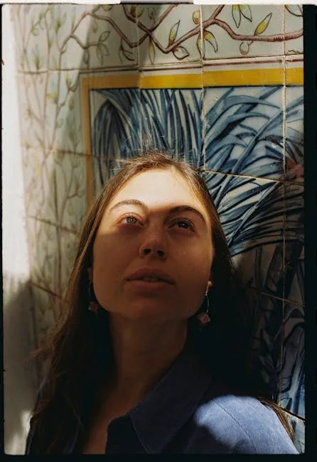 Femme appuyée contre un panneau d'azulejos, ombre traversant son visage