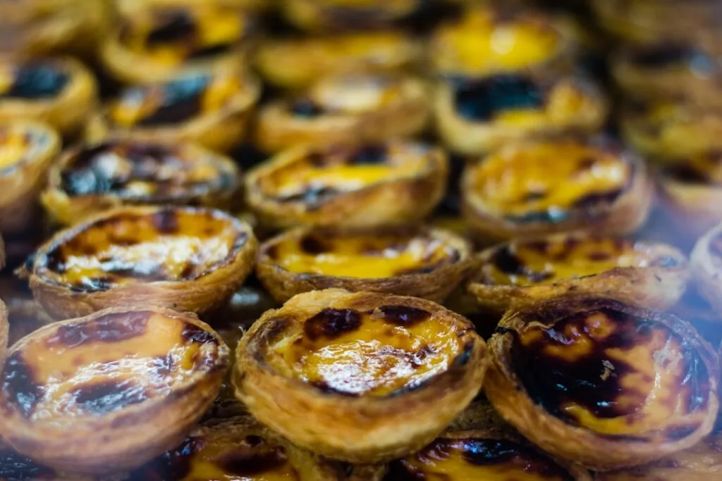 Gros plan de pastéis de nata caramélisés présentés en vitrine à Lisbonne