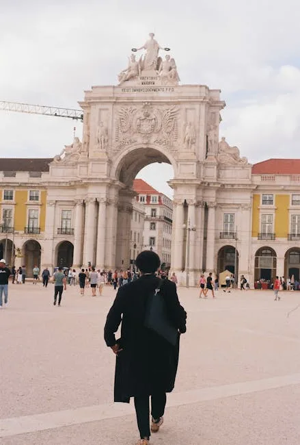 Personne en manteau marchant vers l'Arco da Rua Augusta à Lisbonne