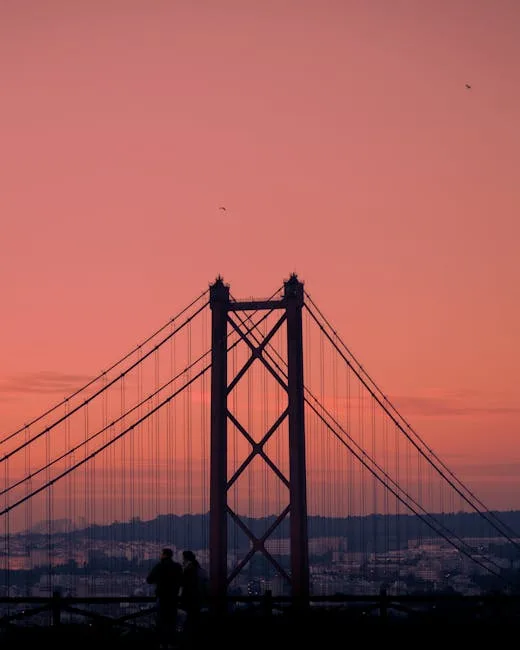 Silhouette du pont 25 de Abril au coucher rose sur Lisbonne