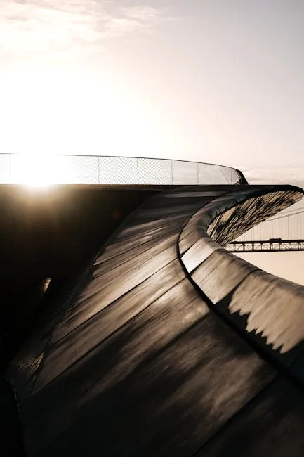 Courbe métallique d'une passerelle moderne à Lisbonne, soleil bas et pont visible