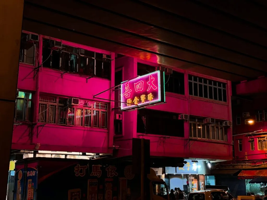 Enseigne néon à caractères chinois sur façade urbaine illuminée