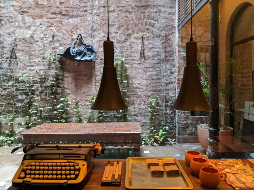 Intérieur avec machine à écrire et lampes suspendues, patio végétal à Lisbonne