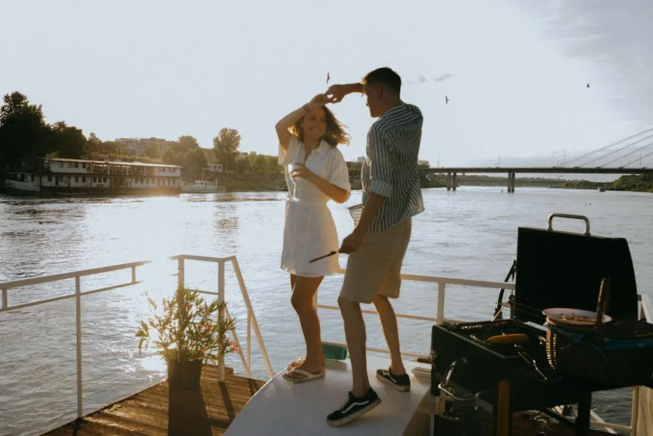 Couple dansant sur le pont d'un bateau au bord d'un fleuve au coucher.