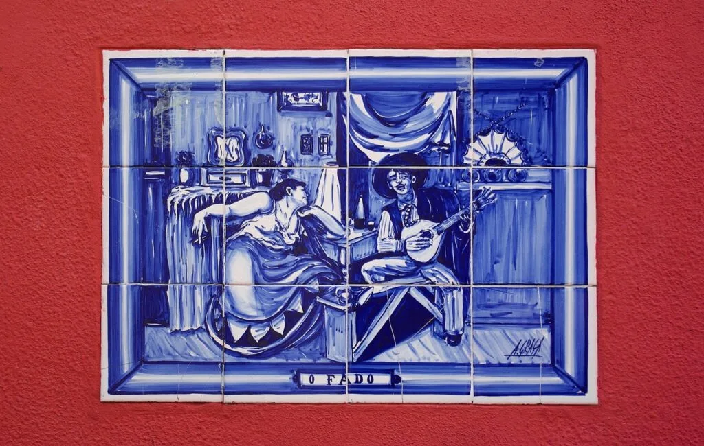 Carreau azulejo bleu représentant une scène de fado sur mur rouge à Lisbonne.