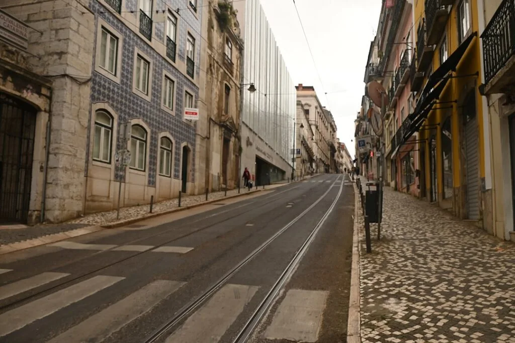 Rue en pente à Lisbonne avec rails de tram et pavés