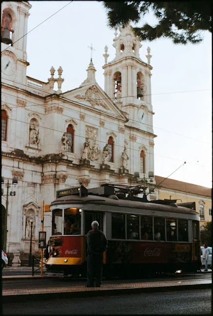 Tramway jaune traditionnel passant devant une église historique à Lisbonne