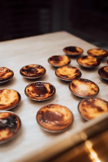 Pastéis de nata alignés dans une vitrine, caramel noirci, à Lisbonne.