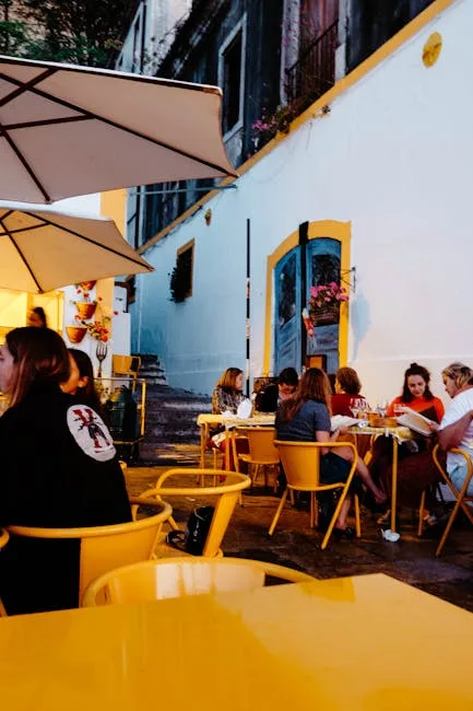 Terrasse animée avec chaises jaunes dans une ruelle de Lisbonne